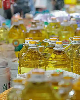 দোকানে বোতলজাত সয়াবিন তেলের সারি, ভোক্তারা উদ্বিগ্ন মুখে দাম যাচাই করছেন।