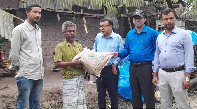 নওগাঁয় ঝড়ে ক্ষতিগ্রস্ত ঘরের টিন উড়ে গেছে, প্রশাসন দুর্গতদের মাঝে শুকনা খাবার বিতরণ করছে।